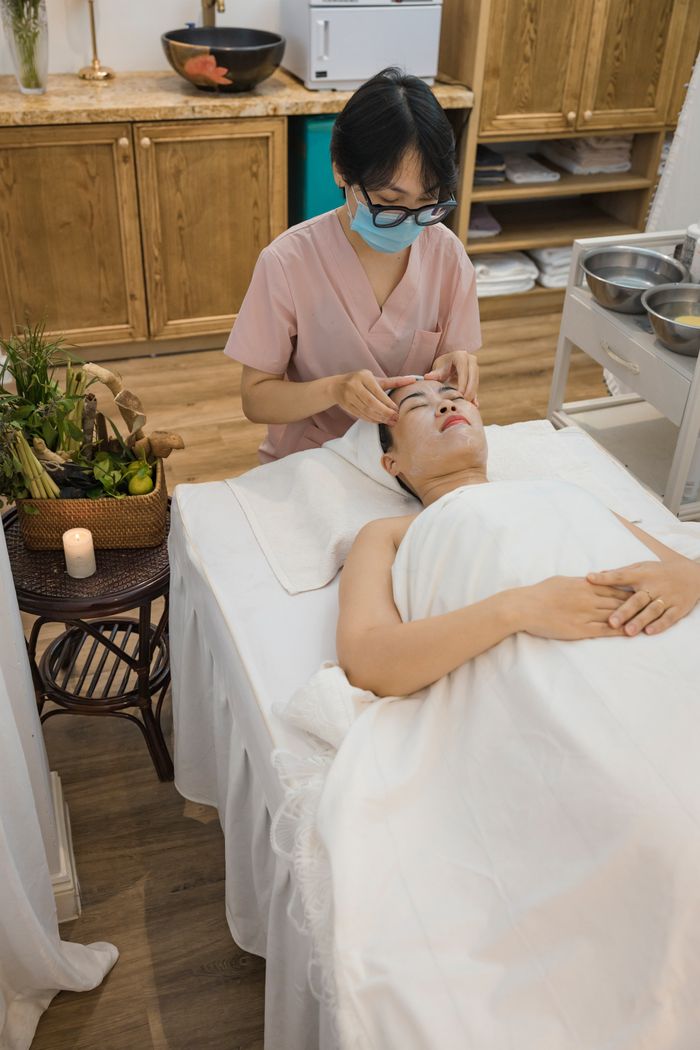 A relaxing spa facial treatment session with a beautician applying skincare in a tranquil setting.